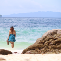 A young lady walking on the beach in sunny Thailand