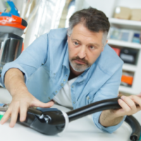 A man trying to fix his vacuum cleaner